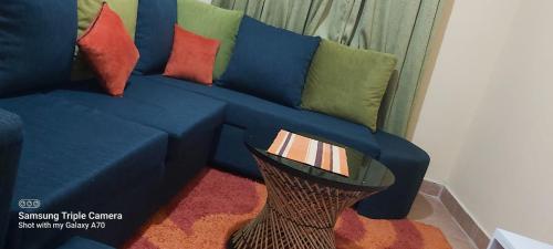a blue couch with colorful pillows in a living room at Annettes Place in Naivasha