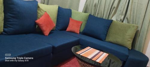 a blue couch with different colored pillows on it at Annettes Place in Naivasha