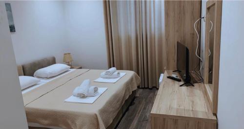 a hotel room with two beds and a television at Deni's Hotel in Sarandë