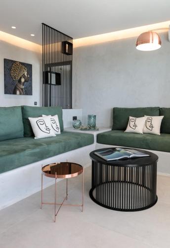 a living room with a green couch and a table at Iphimedeia Luxury Hotel & Suites in Naxos Chora