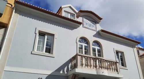 a white house with a balcony at CasAzulApartments in Sintra