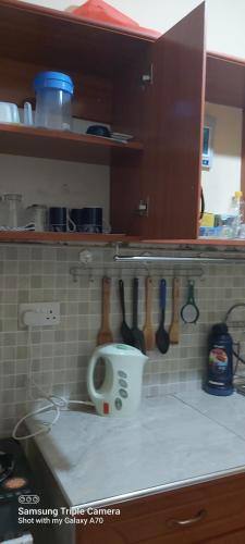 a kitchen counter with a coffee cup and utensils at Annettes Place in Naivasha