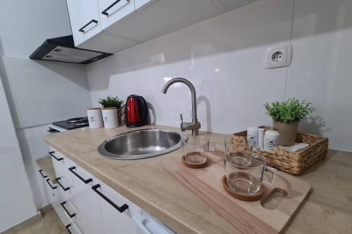 a kitchen counter with a sink and glasses on it at Apartment in the heart of the city 4 in Larisa