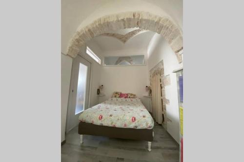 a bedroom with a bed and an archway at Un Cuore e Due Capanne in Ceglie Messapica