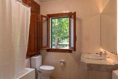 a bathroom with a toilet and a sink and a window at Villa Anna 12B in Son Bou