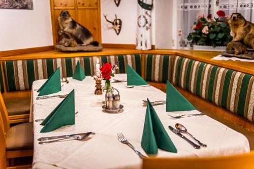 stół z zielonymi serwetkami i przyborami kuchennymi. w obiekcie Landhotel Timmerer w mieście Möderbrugg