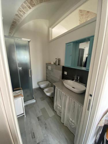 a bathroom with a sink and a toilet and a mirror at Un Cuore e Due Capanne in Ceglie Messapica
