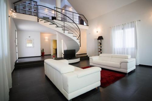a living room with two white couches and a staircase at Villa Margherita in Canicattini Bagni