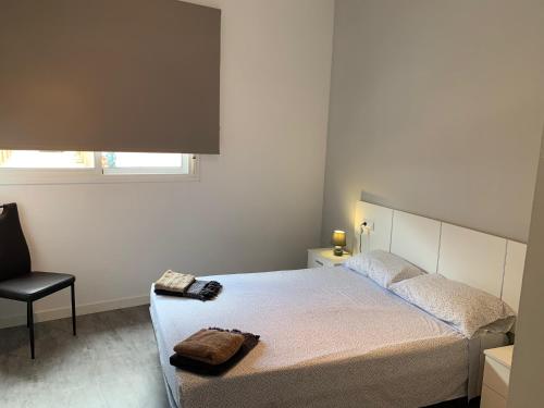 サント・ハウメ・デンヴェハにあるCan Bitxoのベッドルーム1室(ベッド1台、椅子、窓付)