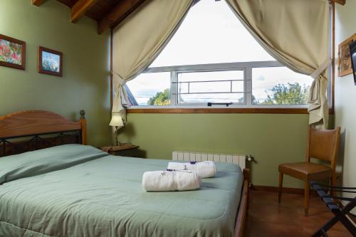 1 dormitorio con 1 cama con 2 toallas en Cabañas Rayuela en San Carlos de Bariloche