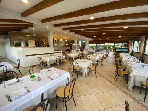 a dining room with white tables and chairs at Al Ristoro in Torre Santa Sabina