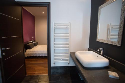 a bathroom with a sink and a mirror and a bed at Villa Margherita in Canicattini Bagni