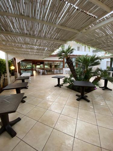 a lobby with tables and palm trees in a building at Al Ristoro in Torre Santa Sabina
