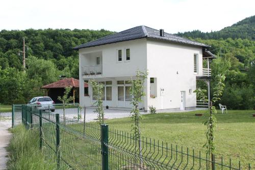 une maison blanche avec une clôture devant elle dans l'établissement Nadia's home, à Ilidža