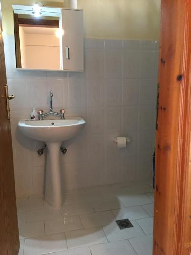 W łazience znajduje się umywalka i lustro. w obiekcie Ilios w mieście Kalamaki