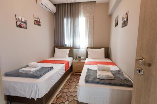 2 łóżka w małym pokoju z oknem w obiekcie Villa Joanna 1 w mieście Mesimérion