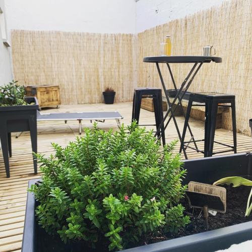 un patio con mesa, sillas y plantas en Le beffroi en Calais