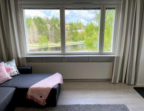 Habitación con sofá y ventana grande. en Citykoti Kuutti, en Savonlinna