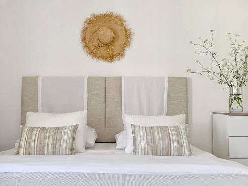 een slaapkamer met een bed met witte lakens en kussens bij Stylish 3 Bedroom Apartment close to the Beach in Monte Gordo