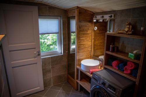 a bathroom with a sink and a washing machine at Hiiumaa Summerhouse in Orjaku