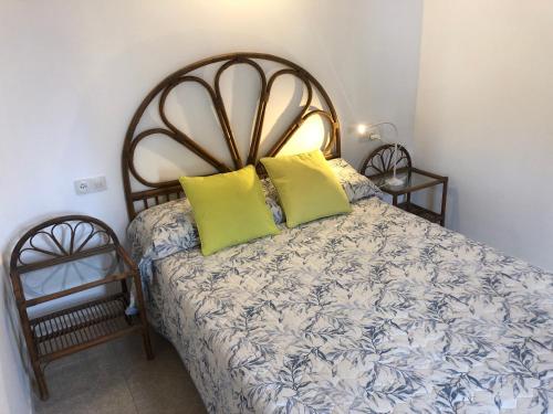 sypialnia z łóżkiem z 2 zielonymi poduszkami w obiekcie Casa Mar con patio en playa de Son Serra de Marina w mieście Son Serra de Marina