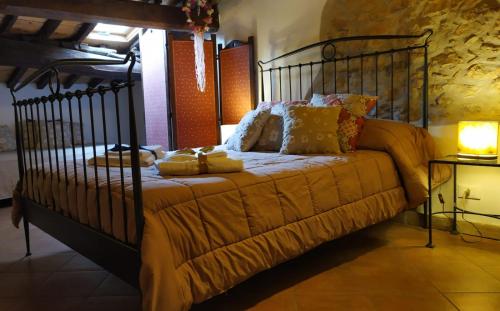 a bedroom with a metal bed with yellow blankets and pillows at La Mora Exclusive in Moricone