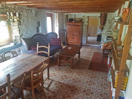 ein Wohnzimmer mit einem Holztisch und Stühlen in der Unterkunft Le Petit Brouillet du bas in La Brévine
