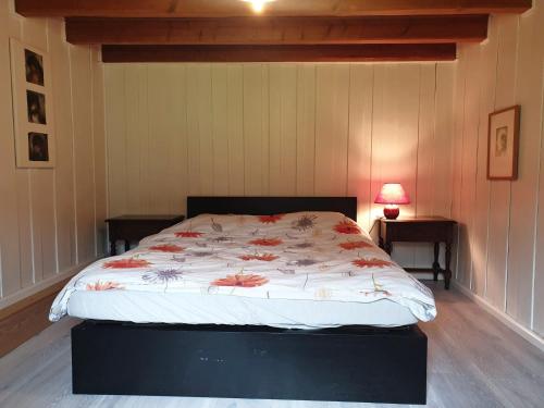 a bedroom with a bed with a flowery comforter at Le Petit Brouillet du bas in La Brévine