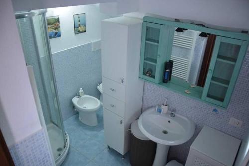 La salle de bains est pourvue d'un lavabo, d'une douche et de toilettes. dans l'établissement La Cuppulata - Stile Classico, à Enas