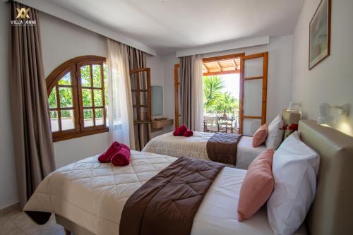 una camera d'albergo con due letti e una finestra di Villa Anni a Città di Skiathos