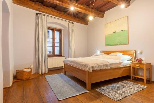 a bedroom with a bed and a window at Babyka Apartments in Český Krumlov