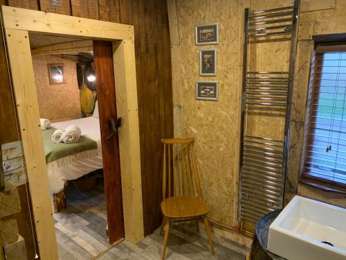 a bedroom with a bed and a chair and a sink at The Bothy Aberlour in Aberlour