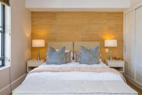 1 dormitorio con 1 cama grande con almohadas azules en Luxury Gallery apartment - Studio 106, en Knysna