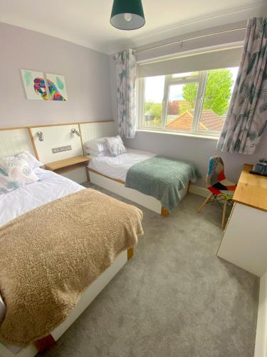 um quarto com 2 camas e uma janela em Orchard House em Swindon