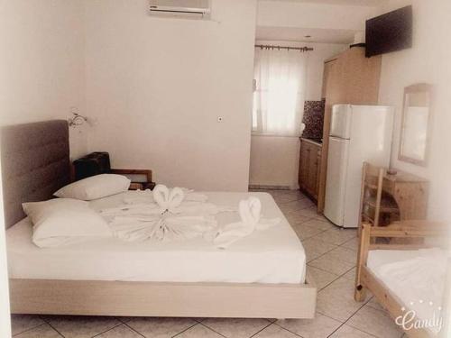 a bedroom with a white bed and a refrigerator at Asterias Studios in Astris