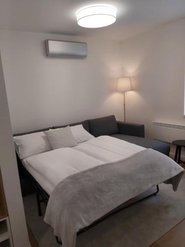 a bedroom with a large bed and a couch at Hello apartman in Eger