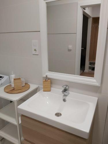 a bathroom with a white sink and a mirror at Hello apartman in Eger
