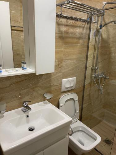 a bathroom with a white sink and a toilet at Persephone in Himare