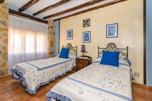Casa lo Ferre في بيسييت: غرفة نوم بسريرين مع وسائد زرقاء