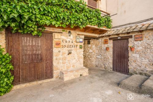 a stone building with two doors and a gate at Casa lo Ferre in Beceite