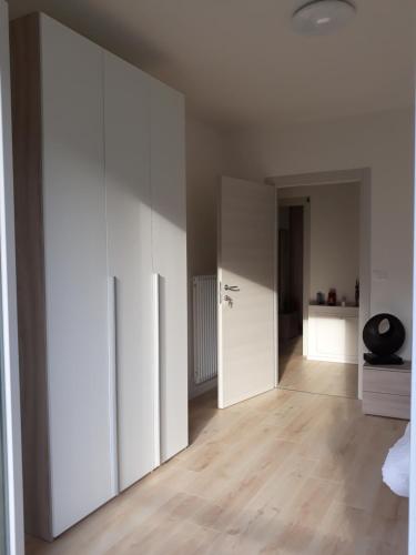 an empty room with white walls and wooden floors at Appartment Lodged Mamma Maria in Mattarello