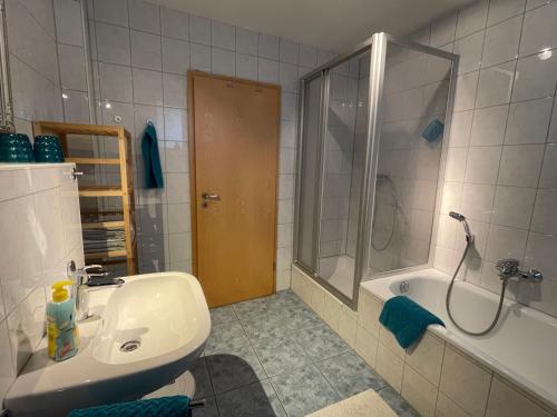 a bathroom with a sink and a shower and a tub at Fewo am kleinen Hafen in Überlingen