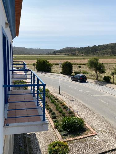 a house with a blue railing on the side of a road at Casa da Várzea in Odeceixe