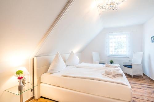 ein Schlafzimmer mit einem weißen Bett im Dachgeschoss in der Unterkunft Gästehaus Schulz in Ahlbeck