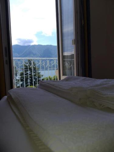 a bedroom with a bed and a window with a view at Hotel Lario in Mezzegra