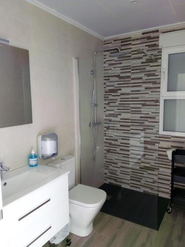 a bathroom with a white toilet and a sink at Casa Pasamee in La Romana