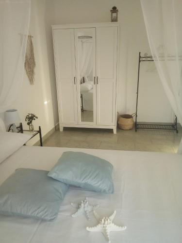 a bedroom with a white bed and a cabinet at Dimora Brezza di Mare in Termoli