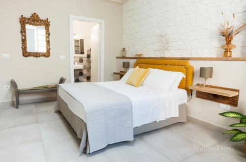 a bedroom with a large bed and a mirror at NEW HOME - appartamento in centro storico in Cagliari