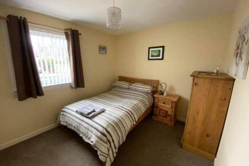 a small bedroom with a bed and a window at The Rothes Retreat in Aberlour