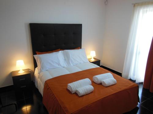 a bedroom with a large bed with two towels on it at Original Apartments in Albufeira